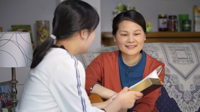 Mother and daughter read Bible and fellowship